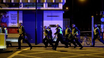 Des policiers courent vers le lieu d'une attaque, à Londres (Royaume-Uni), le 3 juin 2017. (HANNAH MCKAY / REUTERS)