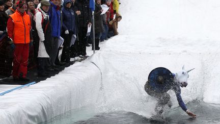 Le public regarde un snowboarder tenter de traverser un bassin d'eau long de 20 m&egrave;tres &agrave; Krasnoyarsk (Russie), le 22 avril 2012. (ILYA NAYMUSHIN / REUTERS)