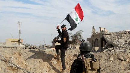 Des soldats de l'armée régulière hissent un drapeau irakien dans la ville de Ramadi (Reuters / Stringer)