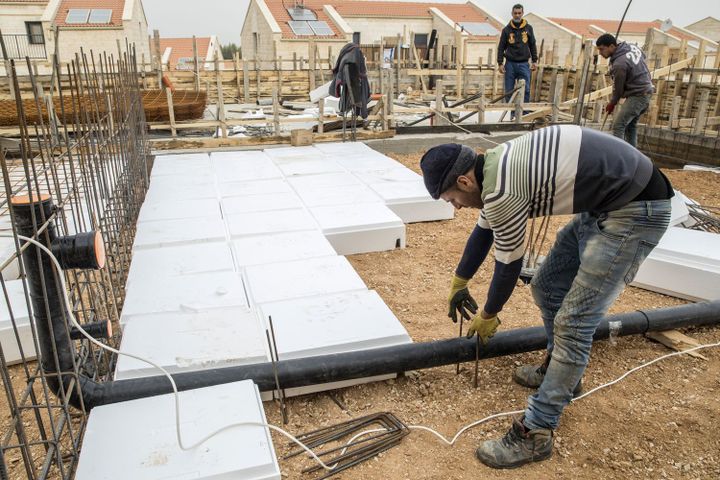 Après l'approbation par le gouvernement israélien de la construction de 2500 logements en Cisjordanie, des ouvriers palestiniens posent de nouvelles infrastructures dans la colonie d'Ariel, près de la ville palestinienne de Naplouse, le 25 janvier 2017. (JACK GUEZ/AFP)