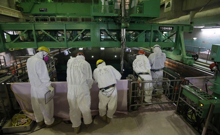 Des employ&eacute;s de la compagnie Tepco inspectent une piscine pleine de combustible us&eacute; dans la centrale de Fukushima, le 6 mars 2013.&nbsp; (ISSEI KATO / AFP)