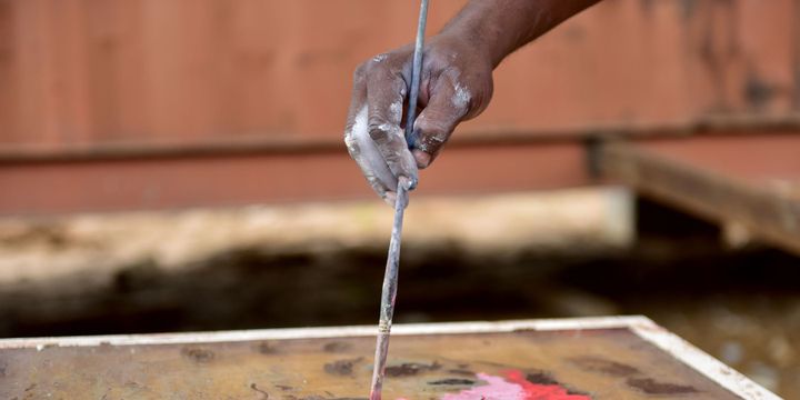 L'artiste togolais Sadikou Oukpedjo peint un de ses tableaux-miroirs
 (Issouf Sanogo / AFP)