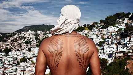 Un homme observe la favela. Sur son dos un tatouage mystique réalisé à l'âge de 16 ans.
 
 (Buyckx Frederik/ANI)