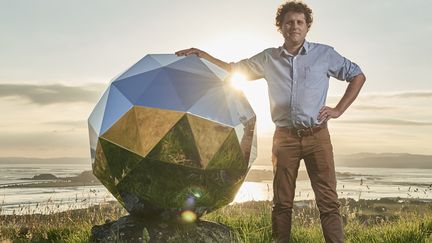 Le fondateur de Rocket Lab, Peter Beck, pose à côté de sa boule à facettes. (ROCKET LAB)