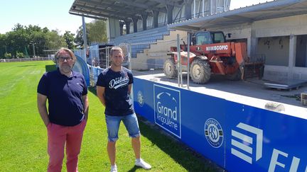 Le manager sportif de l'équipe de football féminine&nbsp;de l'ASJ Soyaux Charente, Louis Dupeyrat (à gauche) et l'entraîneur Sebastien Joseph (à droite) devant les tribunes&nbsp;rénovées.&nbsp; (GUILLAUME BATTIN/ RADIOFRANCE)