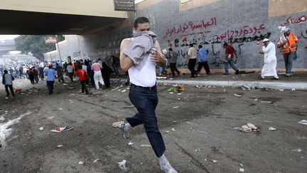 Un manifestant &eacute;gyptien fuit les gaz lacrymog&egrave;nes le 4 mai 2012. (KHALED DESOUKI / AFP)