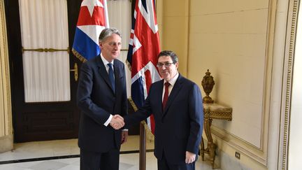 Le ministre britannique des Affaires étrangères Philip Hammond serre la main de son homologue cubain&nbsp;Bruno Rodriguez, le 28 avril 2016 à La Havane (Cuba). (ENRIQUE DE LA OSA / AFP)