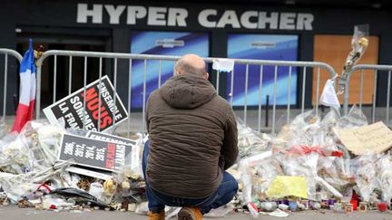  (Un homme se recueille devant l'hyper casher de la porte de Vincennes à Paris, où quatre clients ont perdu la vie lors de l'attaque du 9 janvier © Maxppp)