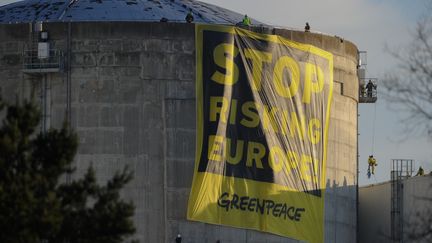 Des militants de l'ONG &eacute;cologistes&nbsp;Greenpeace d&eacute;ploient une banderole "cessez de mettre en dager l'Europe", sur le toit d'un b&acirc;timent de la centrale nucl&eacute;aire de Fessenhein (Haut-Rhin), mardi 18 mars 2014.&nbsp; (SEBASTIEN BOZON / AFP)