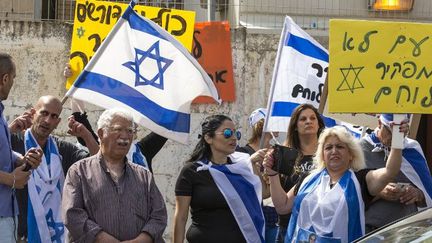 Des Israéliens défendant le soldat Azaria affichent les couleurs nationales à l'entrée de la salle où se tient le procès du soldat accusé d'avoir tué un Palestinien. (JACK GUEZ / AFP)