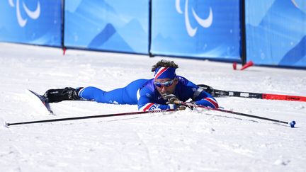 Le Français Benjamin Daviet s'écroule à l'arrivée de la course moyenne distance de biathlon des Jeux paralympiques de Pékin, le 8 mars 2022. (SHUJI KAJIYAMA / AP)