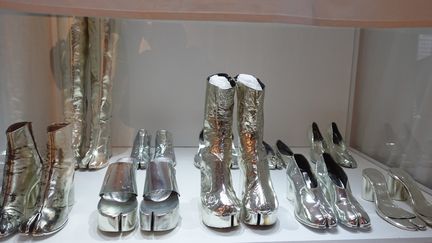 Le travail sur les chaussures tabi a été développé par Martin Margiela tout au long de sa carrière, à travers de nombreuses variantes et en de multiples matières. Elles sont ici représentées par un ensemble en métal argenté qu'il a créé en 2008, à l'occasion de l'exposition célébrant les 20 ans de la maison au musée de la mode d'Anvers. Semelles, sandales, mules, bottines, bottes et cuissardes sont autant de variations de sa première bottine tabi du printemps-été 1989.
 (Corinne Jeammet)