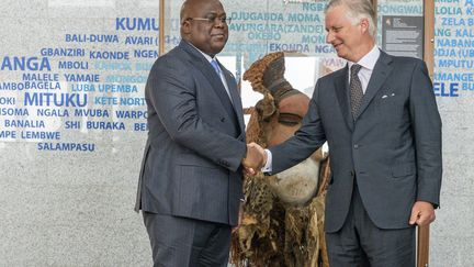 Le roi Philippe de Belgique et le président de la République démocratique du Congo Félix Tshisekedi se serrent la main au moment de la restitution d'un masque à Kinshasa, le 8 juin 2022. (ARSENE MPIANA / AFP)