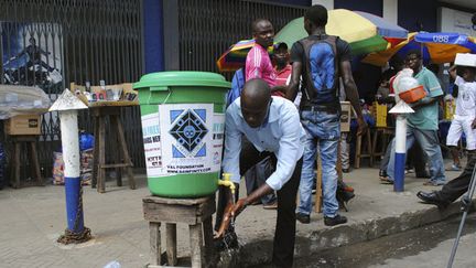 &nbsp; (Un Libérien se lave les mains dans une rue de Monrovia © Reuters/James Giahyue)