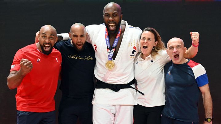 Teddy Riner pose avec sa médaille d'or,remportée aux Mondiaux de Doha en 2023, aux côtés de son préparateur physique Julien Corvo, sa physiothérapeute Armelle O'Brien, son coach Franck Chambily et son sparring Frédéric Miredin. (MILLEREAU PHILIPPE / KMSP)