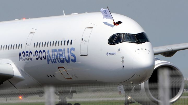 Un membre d'&eacute;quipage brandit un drapeau Airbus apr&egrave;s l'atterrissage de l'A350 pour son premier vol d'essai, &agrave; Toulouse-Blagnac (Haute-Garonne), le 14 juin 2013. (ERIC CABANIS / AFP)