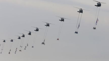 Des militaires des forces sp&eacute;ciales cor&eacute;ennes d&eacute;filent suspendus &agrave; des h&eacute;licopt&egrave;res dans le cadre des c&eacute;l&eacute;brations du 65e anniversaire des forces arm&eacute;es nationales &agrave; Seongnam (Cor&eacute;e du sud), le 1er octobre 2013. (KIM HONG-JI / REUTERS)