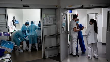 Des soignants travaillent dans l'unité de soins intensifs consacrée au Covid-19, le 7 avril 2021 à PIerre-Benite (Rhône). (JEAN-PHILIPPE KSIAZEK / AFP)