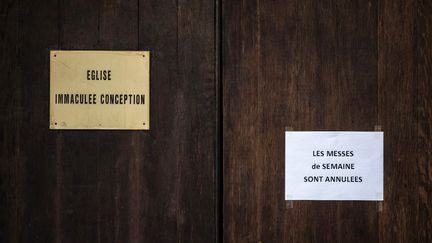 Un écriteau annonce l'annulation des messes sur la porte d'entrée de l'église de l'Immaculée Conception de Lyon, le 15 mars 2016. (JEFF PACHOUD / AFP)