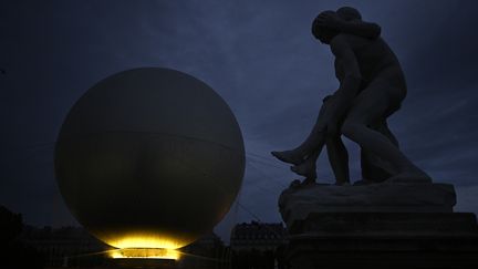 Pour sa dernière soirée, la vasque olympique est restée clouée au sol en raison du mauvais temps, obligeant la programmation à revoir ses plans pour éteindre symboliquement la vasque. (JULIEN DE ROSA / AFP)