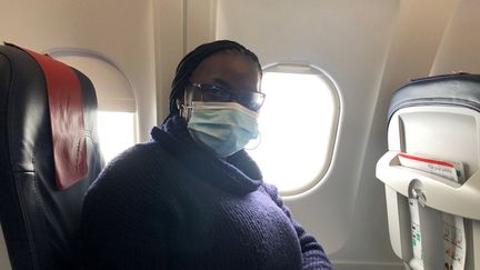 Régine Yao, dans un avion de la compagnie belge Brussels Airlines, le 19 janvier 2021 alors qu'elle rentre en France. La jeune Ivoirienne&nbsp;avait dû prolonger son séjour à Abidjan&nbsp;après avoir découvert qu'elle avait le Covid-19 au moment de prendre son vol retour une dizaine de jours plus tôt. (FG/FRANCEINFO)