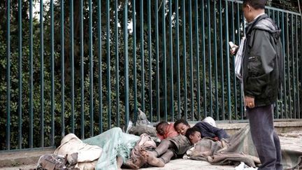 Un passant photographie des enfants qui dorment dans une rue de la capitale éthiopienne, Addis-Abeba.

La famine et les conflits des décennies précédentes, ainsi que le sida ont laissé des milliers d'enfants livrés à eux-mêmes. (AFP PHOTO/JOSE CENDON )