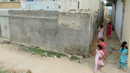 Des enfants jouent autour de la maison de Rimsha Masih. La justice a d&eacute;cid&eacute;,&nbsp;le 7 septembre 2012, de lib&eacute;rer sous caution la jeune Pakistanaise accus&eacute;e d'avoir br&ucirc;l&eacute; des pages du Coran. (AAMIR QURESHI / AFP)