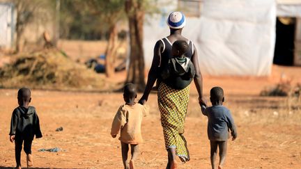 Une femme, qui a fui les attaques armées dans la région du Sahel, et ses enfants dans un camp pour personnes déplacées à l'intérieur du pays à Kaya, au Burkina Faso, le 23 novembre 2020.&nbsp; (ZOHRA BENSEMRA / REUTERS)