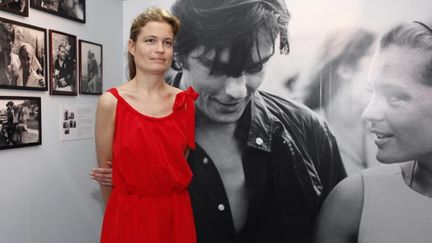 Sarah Biasini, la fille de Romy Schneider, pose devant une photographie de sa mère aux côtés de l'acteur frnaçais Alain Delon, dans le cadre d'une exposition organisée à Cannes en 2012. 
 (VALERY HACHE / AFP)