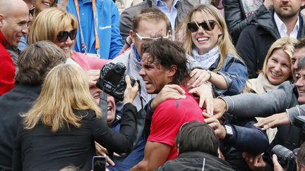 L'Espagnol Rafael Nadal rejoint ses proches dans les tribunes de Roland-Garros &agrave; l'issue de sa 7e victoire dans ce tournoi du Grand Chelem, Paris, le 11 juin 2012. (PATRICK KOVARIK / AFP)