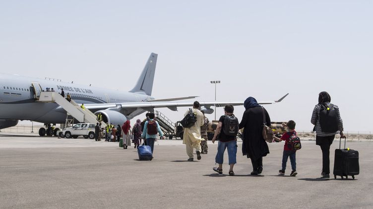 Des personnes évacuées d'Afghanistan embarquent à bord d'un vol de l'Armée de l'air à destination de la France, à Abou Dhabi (Emirats Arabes Unis), le 20 août 2021. (HANDOUT / ETAT MAJOR DES ARMEES / AFP)