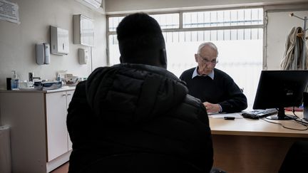 Un médecin membre de l'Association Médecine et Droit d'Asile avec un réfugié, à Lyon, le 2 avril 2019. (JEFF PACHOUD / AFP)