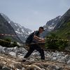 Un habitant marche au milieu des débris pour récupérer des effets personnels dans les décombres de sa maison après la crue dévastatrice du Vénéon, dans le hameau de La Bérarde (Isère), le 28 juin 2024. (ARNAUD FINISTRE / AFP)