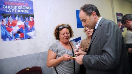 Jean-François Copé signe un autographe pour une militante UMP, à Mèze (Héraut), le 30 mai 2012. (AFP - Sylvain Thomas)