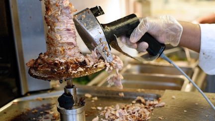 Un employé découpe de la viande de kebab, à Paris, le 13 septembre 2013.&nbsp; (THOMAS SAMSON / AFP)