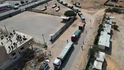 Une file de camions attend de pouvoir passer livrer l'aide humanitaire aux habitants de la bande de Gaza, au poste-frontière de Rafah (Egypte), samedi 21 octobre 2023. (MOHAMMED ABED / AFP)