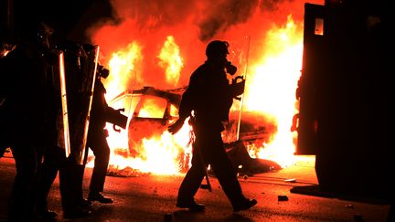 La police poursuit des manifestants dans les rues de Ferguson, dans le Missouri (Etats-Unis), le 24 novembre 2014. (JEWEL SAMAD / AFP)