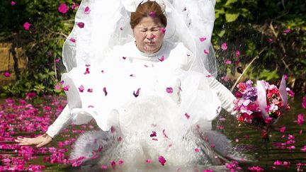 Une jeune mari&eacute;e participe &agrave; des &eacute;preuves pour prouver son amour en marge des c&eacute;l&eacute;brations de la Saint-Valentin dans la province de Prachinburi (Tha&iuml;lande), le 13 f&eacute;vrier 2012. (NATITA PHODEE / MAXPPP)