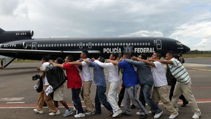 Ceci n'est pas une chenille mais des prisonniers escort&eacute;s par des policiers f&eacute;d&eacute;raux sur le tarmac de l'a&eacute;roport de Morelia (Mexique), le 21 ao&ucirc;t 2012. (REUTERS)