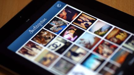 Un &eacute;cran de smartphone affichant des photos dans Instagram, une application qui propose des filtres pour vieillir artificiellement ses clich&eacute;s et permet de les partager avec son r&eacute;seau d'amis, &agrave; Paris, le 10 avril 2012. (THOMAS COEX / AFP)