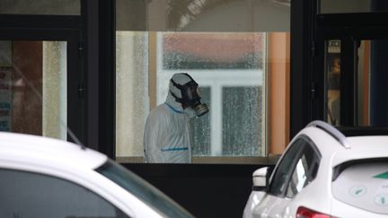 Un homme en combinaison désinfecte le collège La Fontaine à Crépy-en-Valois (Oise), le 29 février 2020. (MAXPPP)