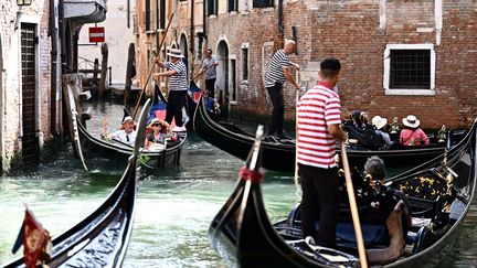 Des touristes font une promenade en gondole le 3 septembre 2023 à Venise. L'ONU a déclaré le 14 septembre 2023 qu'elle n'avait pas réussi à inscrire Venise, l'une des principales destinations touristiques au monde, sur sa liste du patrimoine mondial "en danger". (GABRIEL BOUYS / AFP)