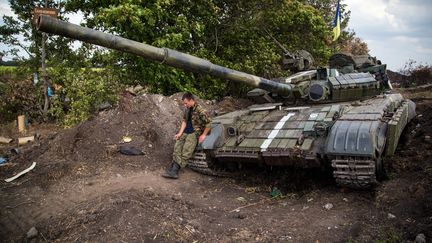 Un soldat ukrainien et son tank, dans l'est de l'Ukraine, pr&egrave;s de Donetsk,&nbsp;le 25 ao&ucirc;t 2014.&nbsp; (OLEKSANDR RATUSHNIAK / AFP)