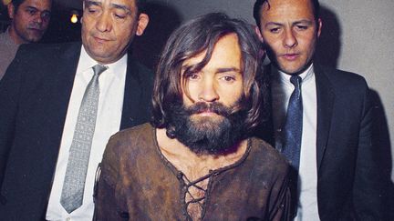 Le tueur en série Charles Manson escorté par des officiers après avoir été accusé de conspiration et de meurtre dans le cadre de l'affaire Sharon Tate, à Los Angeles, en 1969. (ANONYMOUS / AP / SIPA)