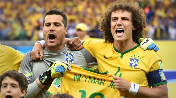 Julio Cesar et David Luiz chantent l'hymne br&eacute;silien au stade de Belo Horizonte, mardi 8 juillet, avec un maillot de Neymar &agrave; la main. (MARCUS BRANDT / DPA / AFP)