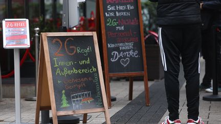 Une file d'attente devant un bar à Cologne, en Allemagne, où est en place la règle "2G" : seules les personnes vaccinées ou guéries peuvent y entrer. (OLIVER BERG / DPA via AFP)