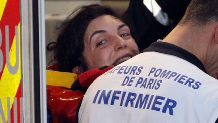 La journaliste Edith Bouvier, couch&eacute;e sur un brancard, sourit &agrave; son arriv&eacute;e en France, le 2 mars 2012 &agrave; l'a&eacute;roport de Villacoublay (Yvelines). (JACQUES DEMARTHON / AFP)