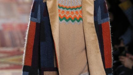 Les mannequins ont défilé sur des kilims, ces tapis orientaux colorés aux formes géométriques. Motifs que l'on retrouve sur plusieurs manteaux ou vestes mais dans des couleurs plus hivernales avec du gris et du beige. Les manteaux Valentino, en cachemire, se portent oversize. Les deux créateurs Maria Grazia Chiuri et Pierpaolo Piccioli donnent l'impression de pouvoir interpréter le costume à l'infini. Il se porte avec de grosses baskets blanches. Tout en reprenant les classiques rayures tennis, un costume bleu marine prend une allure décontractée avec une coupe-pyjama: les épaules tombent, la veste se ferme avec quatre boutons jusqu'en bas du cou. Un autre porte des motifs camouflage. A noter aussi une longue cape élégante, une combinaison pétrole près du corps, un blouson rock qui mixe cuir et longs poils bruns. Chez Valentino, la couture n'est "jamais exhibée mais toujours évidente aux yeux de ceux qui savent et veulent savoir", souligne la maison dans une note remise aux invités. La maison inaugurait le jour même sa nouvelle boutique homme située rue Saint Honoré à Paris.
 (PATRICK KOVARIK / AFP)