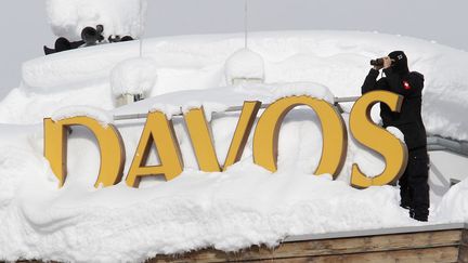 Un membre des forces sp&eacute;ciales de s&eacute;curit&eacute; suisse en poste sur le toit d'un h&ocirc;tel &agrave; Davos (Suisse), le 24 janvier 2012. (CHRISTIAN HARTMANN / REUTERS)