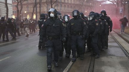 Des policiers lors d'une manifestation contre la vaccination obligatoire, le 11 décembre 2021, à Vienne (Autriche). (FLORIAN WIESER / APA / AFP)